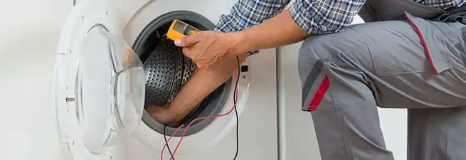Dryer repair technician inspecting and repairing a clothes dryer in Chicago, IL