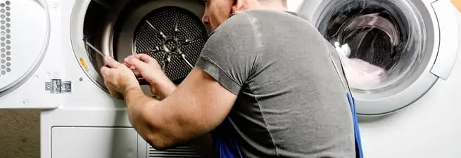 Dryer repair technician fixing a clothes dryer drum in Chicago, IL