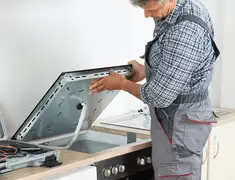 Appliance repair technician installing a built-in cooktop in Chicago, IL