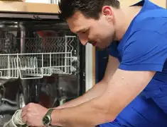 Dishwasher repair technician inspecting and servicing an open dishwasher in Chicago, IL