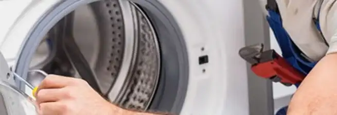 Appliance technician repairing a clothes dryer drum and internal parts in Chicago, IL