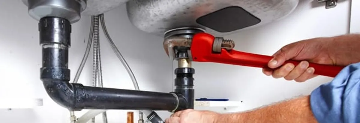 Garbage disposal repair technician tightening the sink drain and disposal connection in Chicago, IL