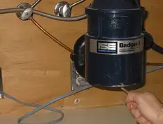 Garbage disposal repair technician tightening the mounting ring under a sink in Chicago, IL
