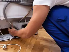 Appliance repair technician fixing refrigerator water line and connections in Chicago, IL
