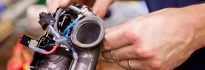 Vacuum repair technician reconnecting wiring and components in Chicago, IL