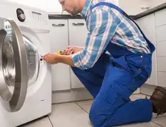 Washing machine repair technician servicing a front-load washer in Chicago, IL