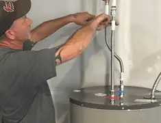 Water heater repair technician tightening supply line connections in Chicago, IL
